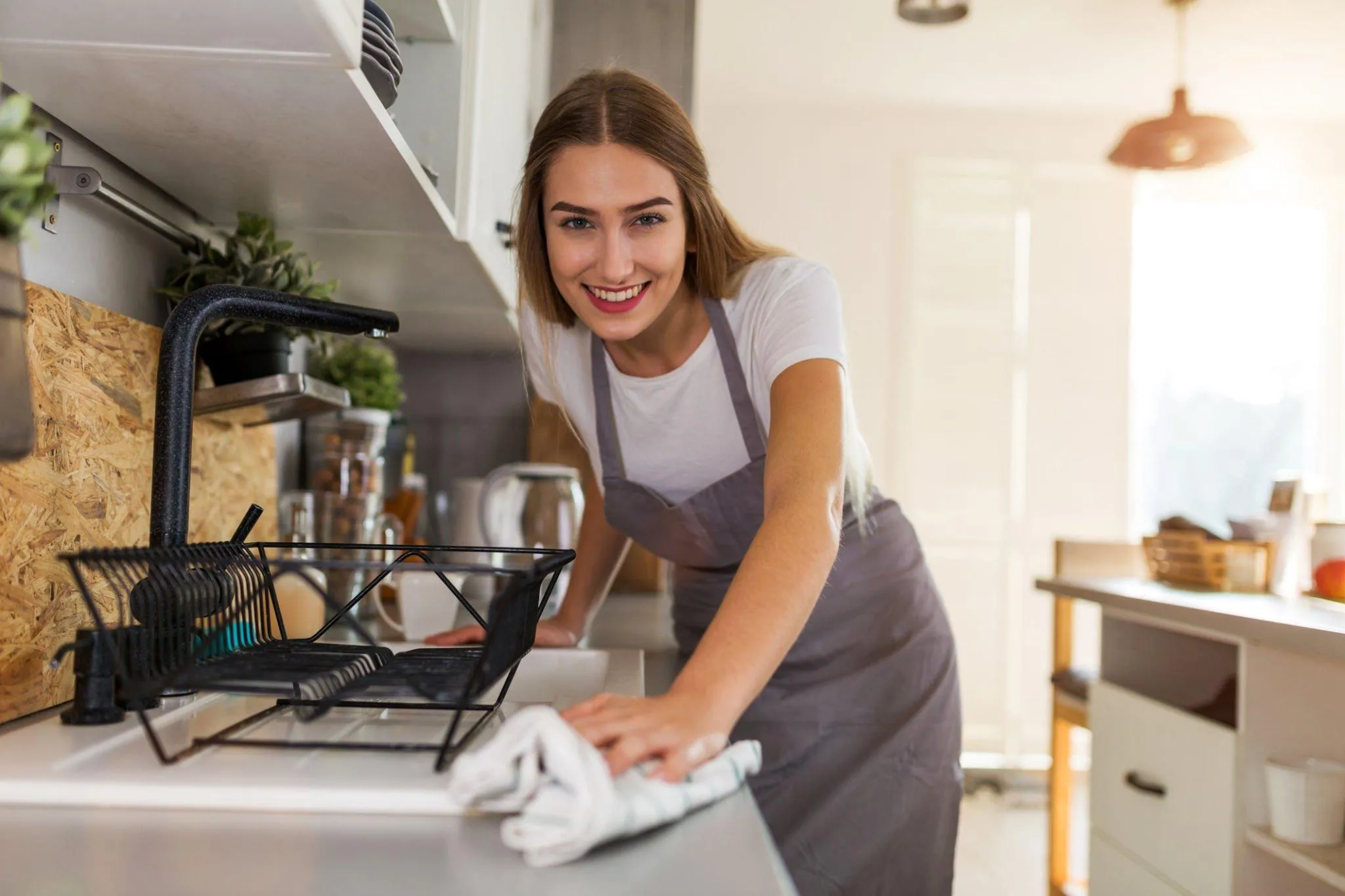 Cleaner wiping down kitchen counters after a party event